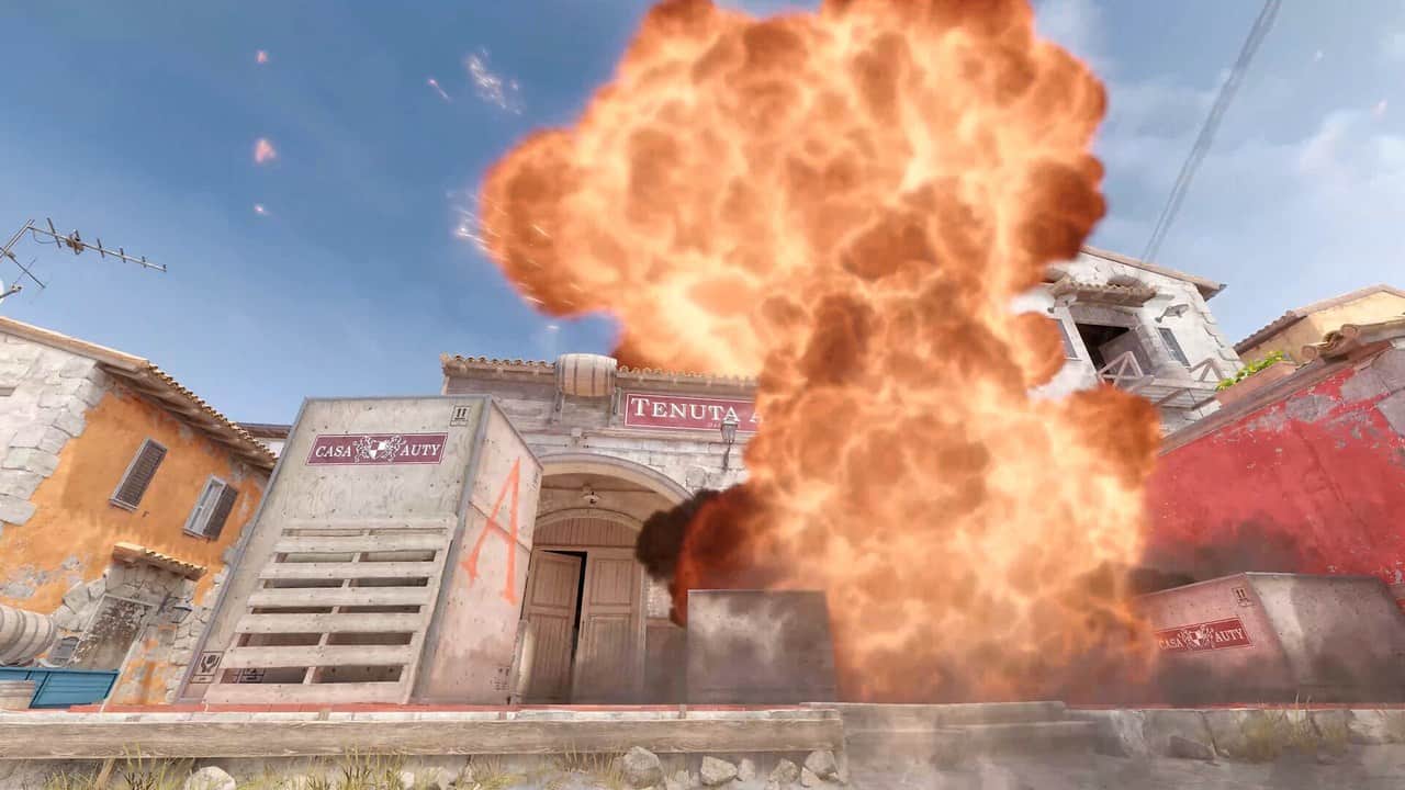 A large explosion in front of colourful buildings on a Counter-Strike 2 map