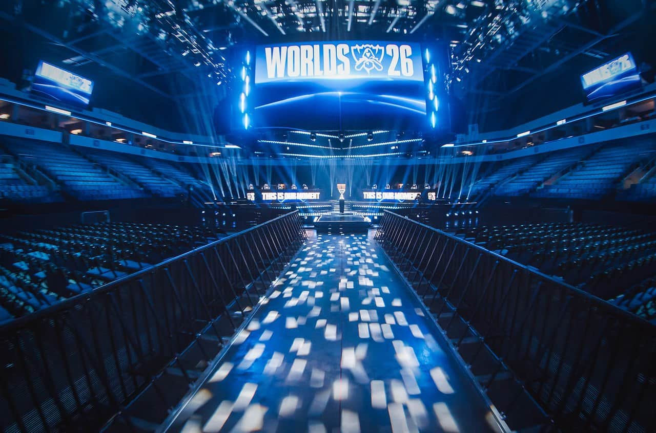 The empty Worlds 2026 Swiss Stage arena lit in blue, with the stage and stands