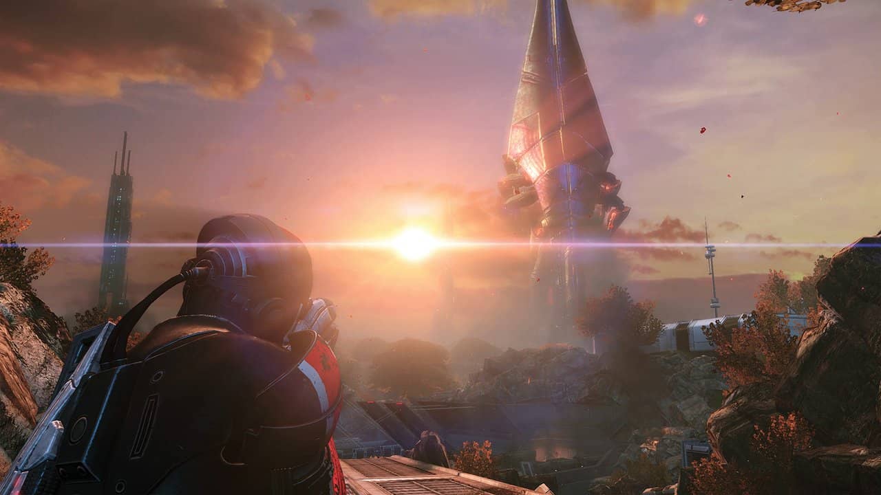 Commander Shepard looking at a giant Reaper over a ruined city at sunset in Mass Effect