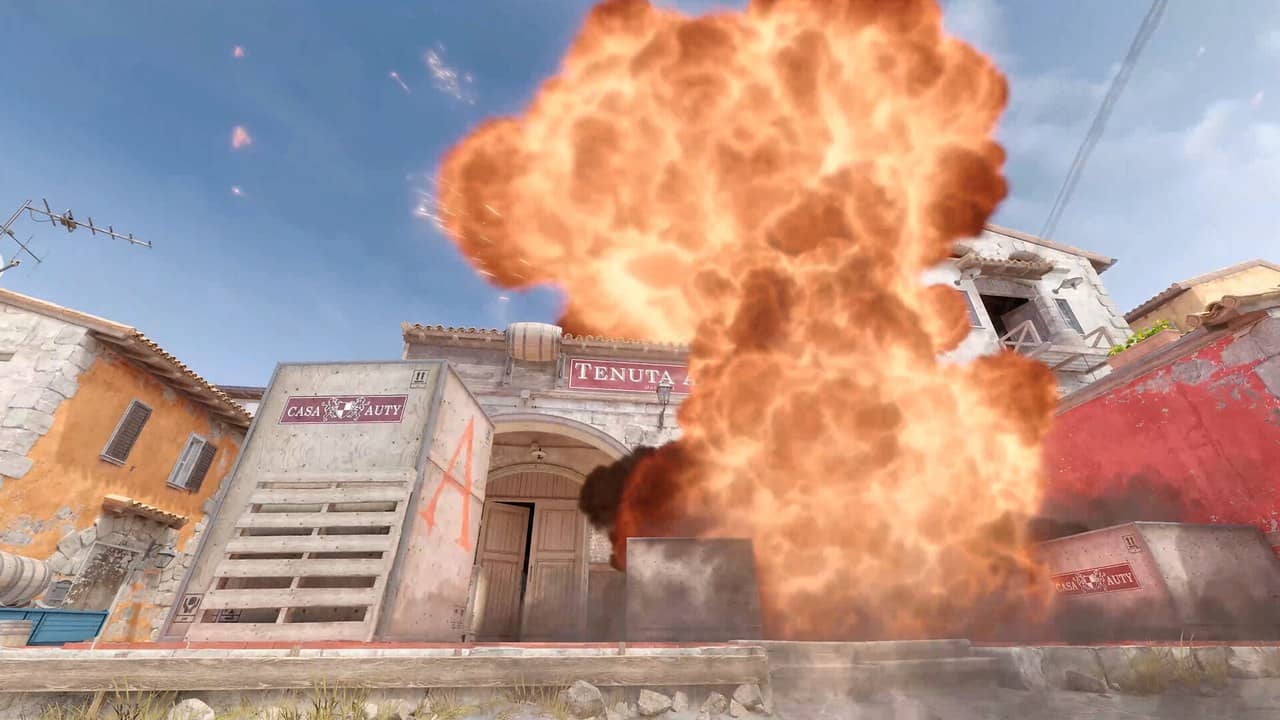 A large explosion in front of colourful buildings on a Counter-Strike 2 map