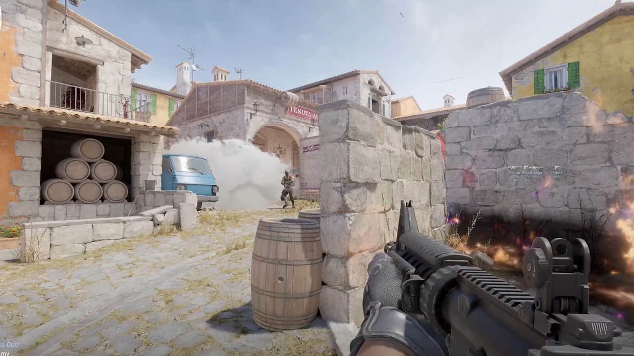 First-person view of a player advancing with a rifle down a sunlit Mediterranean street in Counter-Strike 2