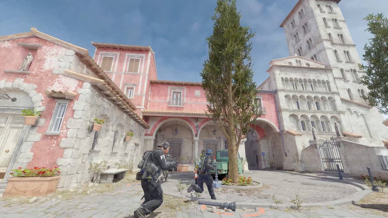Two Counter-Strike 2 players crossing a square between colourful buildings